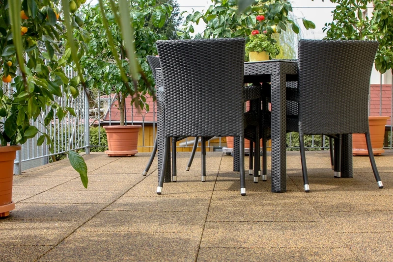 Sur un toit-terrasse, couvert de dalles WARCO carrés de couleur Maroc, se trouve un coin salon avec des agrumes.