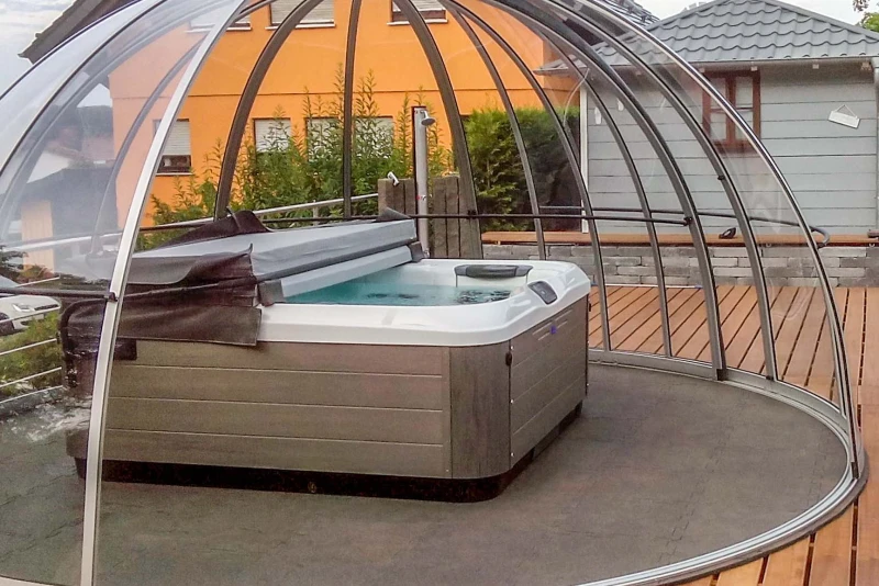 Le spa privé extérieur dans le jardin aménagé de manière fonctionnelle avec un abri semi-ouvert, un bain tourbillon et le sous-plancher pour piscine WARCO.