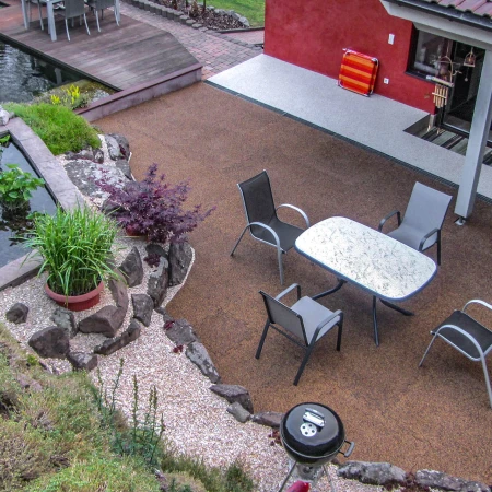 L'oasis de bien-être idyllique pour la famille entre la pente et la maison. La terrasse spacieuse en dalles WARCO et un étang naturel invitent à la détente.