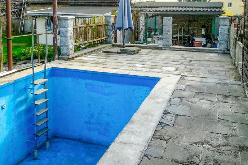 La piscine enterrée et son entourage dans le jardin sont complètement abîmés par les intempéries et 
ont besoin d'une rénovation complète.